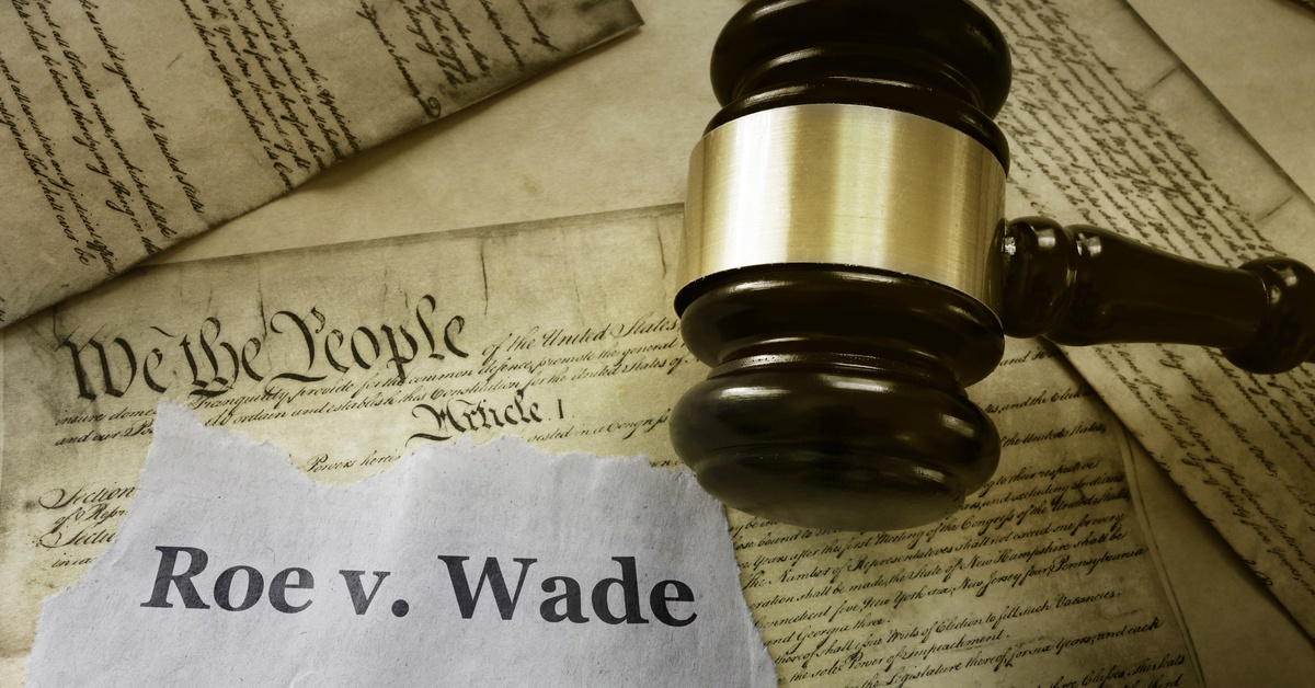 Multiple copies of the Amendments of the United States underneath a gavel and piece of torn paper that reads
