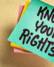 A stack of turquoise, yellow, and pink post-it notes, with the top note displaying 