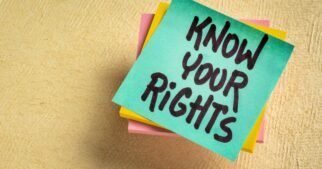 A stack of turquoise, yellow, and pink post-it notes, with the top note displaying 