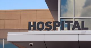 The exterior of a hospital, with a large sign reading