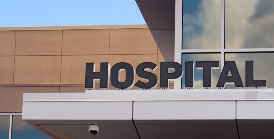 The exterior of a hospital, with a large sign reading 